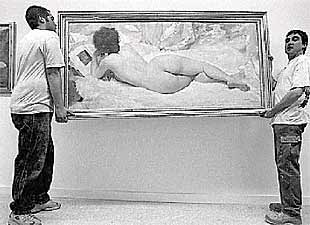 Dos operarios ultiman la colocación de las obras del Bellas Artes.