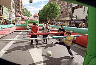 Varios niños jugaban ayer dentro de un futbolín gigante instalado en la calle de Bravo Murillo.