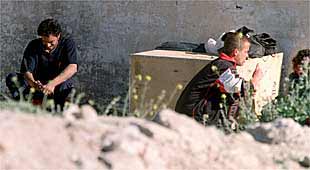 Dos toxicómanos junto a un muro en el poblado de Las Barranquillas.