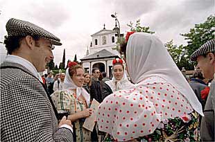 Chulapos y chulapas charlaban ayer o disfrutaban de un aperitivo campestre en la pradera de San Isidro.