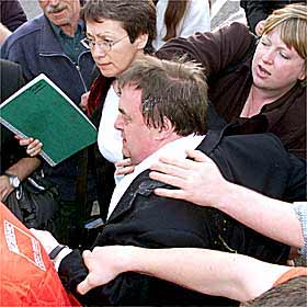 John Prescott, en el centro, es ayudado a entrar en el mitin laborista de Gales tras ser agredido ayer.