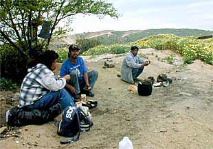 Un grupo de mexicanos espera una oportunidad para cruzar la frontera con EE UU desde Tijuana, el 17 de mayo.