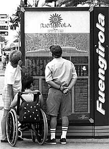 Un grupo observa un cartel de información turística en Fuengirola.