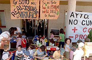 Un grupo de padres de alumnos de primaria de Soto del Real, ayer, frente al Ayuntamiento.
