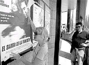 Una joven coloca un cartel exhibidor en los nuevos cines de Vitoria.