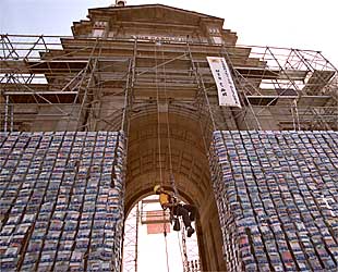 Un operario coloca sobre la Puerta de Alcalá los libros donados por los madrileños.