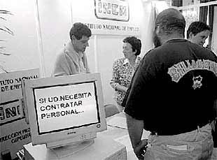 Unas personas en un puesto de la feria de empleo de hostelería.