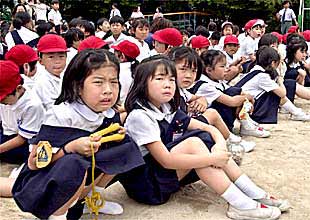 Niños de la escuela Ikeda (Osaka), ayer, asustados en el patio de su colegio tras el asalto en el que murieron ocho de sus compañeros.