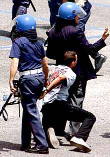 La policía arresta a un aficionado del Roma, ayer en Nápoles.