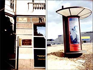 Un poste de señalización de una calle, bajo el rótulo existente en la fachada (a la izquierda), y un chirimbolo en un descampado.