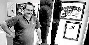 Koldobika Jáuregui ante dos de las esculturas en madera que expone en la galería.