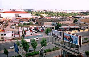 Las instalaciones de la Fira, al fondo, bloqueadas en su acceso a la Gran Via por algunos negocios, en primer término.