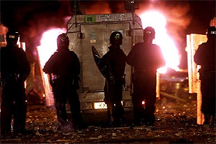 La policía norirlandesa se parapeta ante los lanzamientos de  cócteles mólotov , durante los disturbios de Belfast.