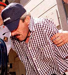 Carlos. B. Q. acompañado por la policía al salir del juzgado.