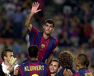 Guardiola, levantado a hombros por sus compañeros, saluda al público del Camp Nou.