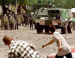 Dos jóvenes arrojan piedras a la policía en la manifestación bereber de Tizi Uzu.