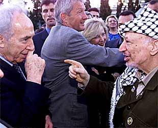 Yasir Arafat (derecha) conversa con el ministro de Exteriores israelí, Simón Peres, ayer en Lisboa.