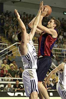 Gasol intenta lanzar ante Struelens en el final de la Liga