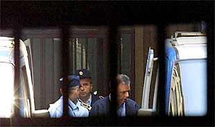 Radomir Markovic (derecha), ex jefe de la policía política durante el régimen de Milosevic, escoltado por policías después de ser condenado a prisión.