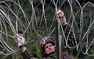 Un ingeniero del Ejército británico tiende una alhambrada en Dumcree, Portadown, para evitar la entrada de los orangistas en el distrito católico.
