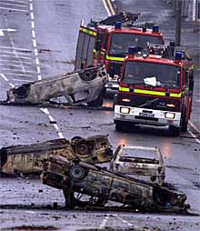 Los servicios de emergencia sortean unas barricadas de coches destrozados, ayer en Bradford.