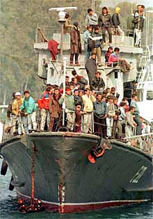 Decenas de albaneses llegan al puerto italiano de Brindisi, en 1997.