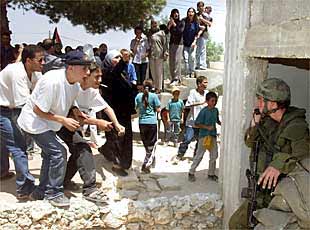 Varios palestinos increpan a los soldados israelíes que ayer tomaron una casa en la aldea de Nabi Saleh, en Cisjordania.
