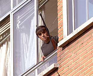 Una mujer de la familia Teixeira se asoma, armada con una escopeta, a la ventana de la vivienda del doble crimen del domingo en Valladolid.