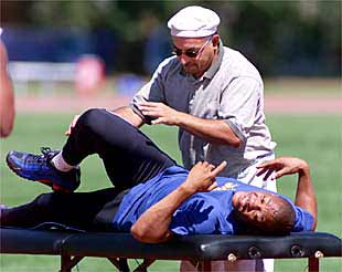 El velocista estadounidense Maurice Grene recibe la atención de un masajista.