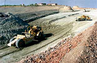 Dos máquinas allanan el terreno en un tramo próximo al municipio de Paracuellos de Jarama.