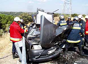 Los bomberos trabajan en el rescate de los heridos en el accidente de tráfico ocurrido ayer cerca de Boadilla del Monte.