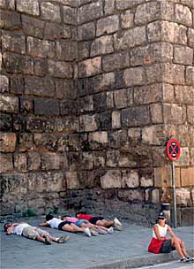 Un grupo de turistas descansaba ayer a la sombra de la muralla del Alcázar de Sevilla.