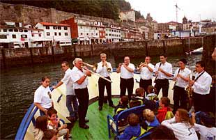 La banda La Donostiarra deleitó ayer con su música a los niños de San Sebastián a bordo de un barco.
