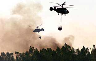 Equipos del servicio aéreo contra incendios de la Junta trabajaban ayer en la extinción del fuego registrado en la sierra de Huelva.