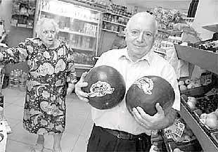 Un frutero del mercado de La Bretxa sostiene dos sandías.