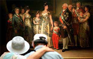 Dos visitantes contemplan    La familia de Carlos IV  de Goya, en el Museo del Prado.