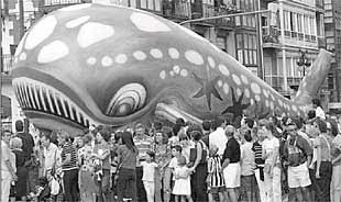 Espectadores rodeaban, ayer, la gran ballena hinchable antes de que alzara el vuelo para presidir la cabalgata.