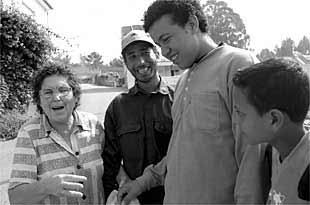 Vecinos marroquíes de Vilaboa charlan con una vecina mientras esperan para realizar el casting.