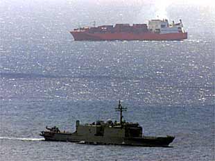 El carguero noruego  Tampa  (al fondo) maniobra alrededor del buque de guerra australiano  Manoora .