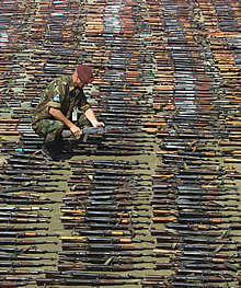 Un soldado de la OTAN cuenta los fusiles de asalto AK-47.