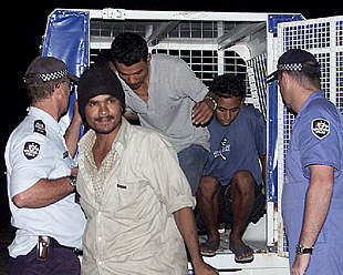 La policía australiana custodia a miembros de la tripulación del  Tampa , que rescató a los inmigrantes.