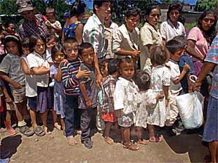 Un grupo de madres con sus hijos hace cola para recibir pan en Matagalpa, al norte de Managua.