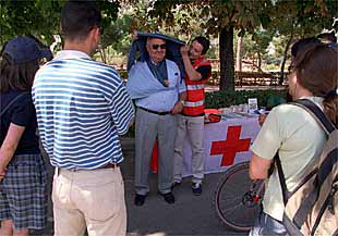 Un miembro de la Cruz Roja enseña nociones de primeros auxilios a los paseantes del Retiro.