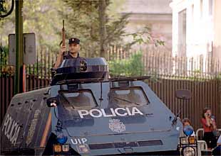 Un policía español protege desde un vehículo blindado la embajada de los EE UU en Madrid.