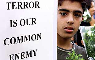 'El terror es nuestro enemigo común', reza el cartel que exhibe un joven palestino ante el Consulado de EE UU en Jerusalén Este.