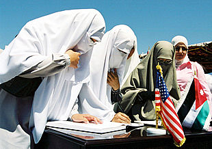 Mujeres jordanas firman en el libro de condolencias abierto en la embajada de EE UU en Ammán.