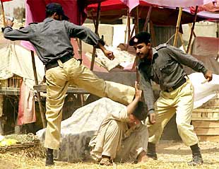 Unos policías paquistaníes arremeten contra un manifestante, ayer.