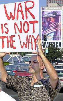 Andy Manoff sostiene un cartel contrario a la guerra (