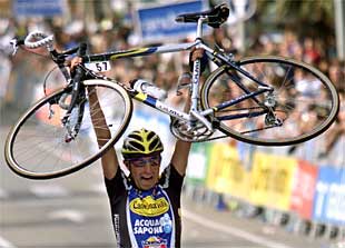 Siemoni, ganador en solitario, alza su bicicleta tras bajarse de ella a cinco metros de una meta que cruzó a pie.