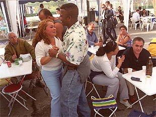 Una pareja baila en un puesto del mercadillo de productos colombianos situado frente al Doce de Octubre.